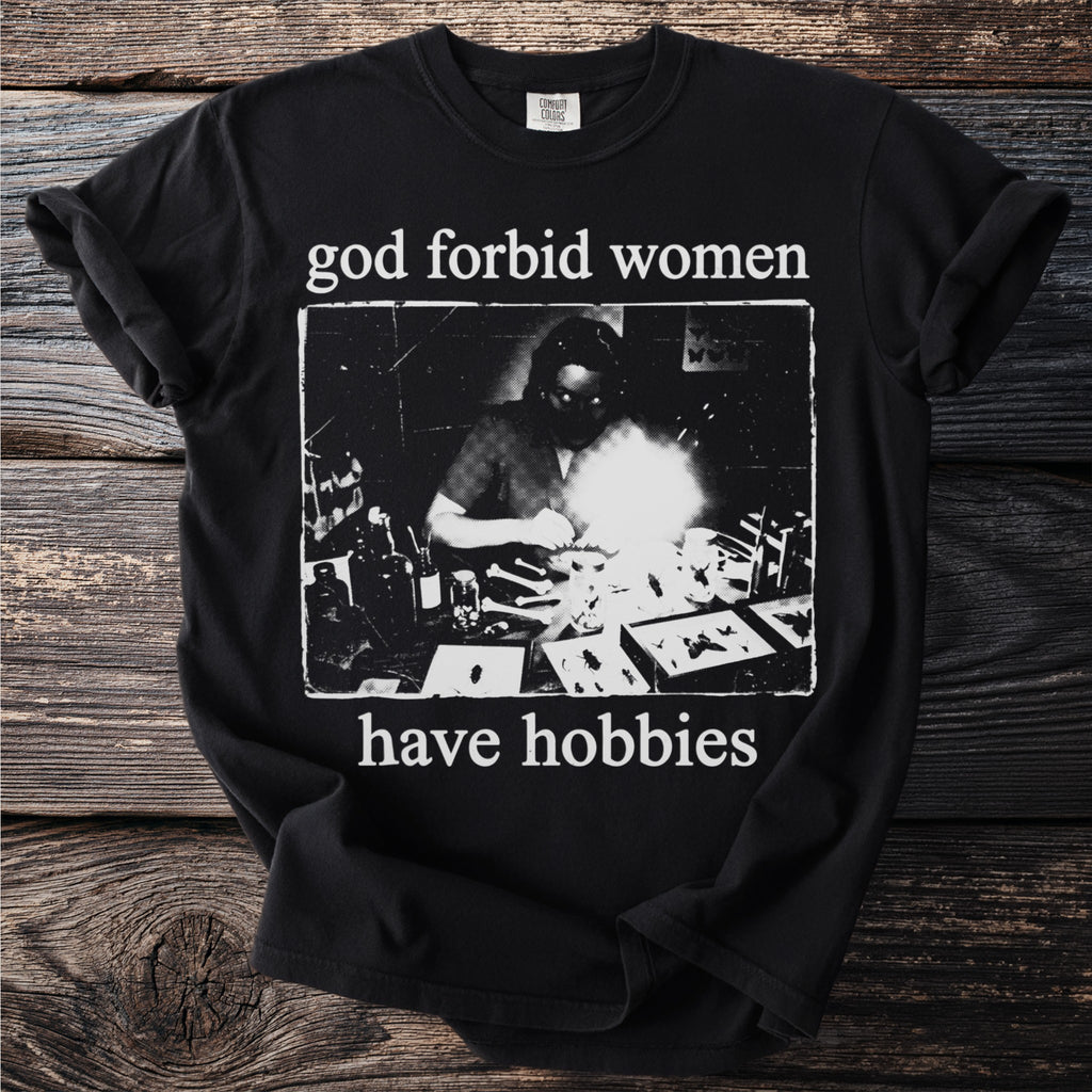 Black t-shirt with text "god forbid women have hobbies" and a vintage image.