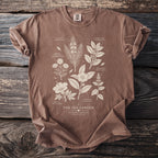 Brown shirt with botanical illustrations of tea garden plants and text.