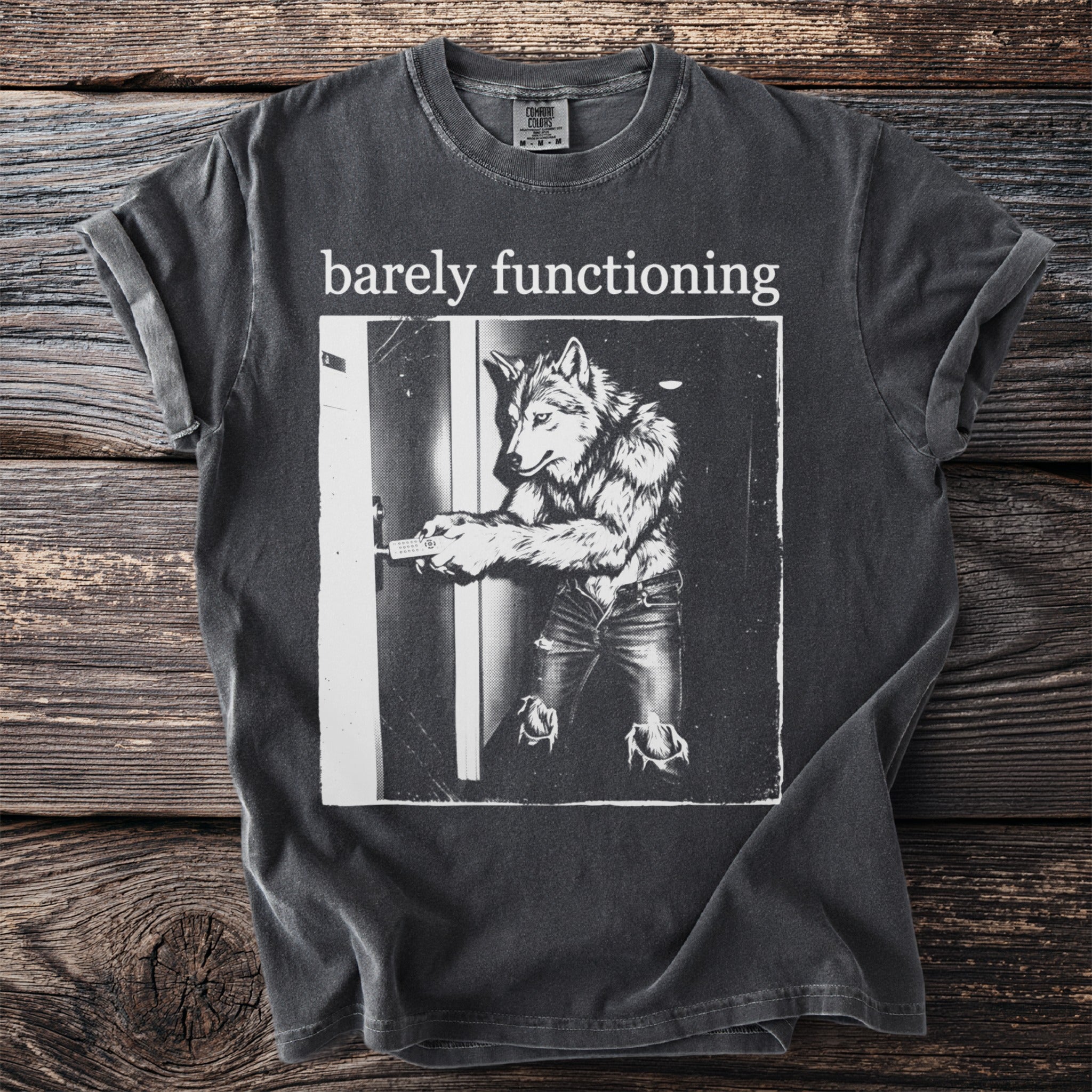 Dark grey t-shirt with "barely functioning" text and a wolf-man opening a door.