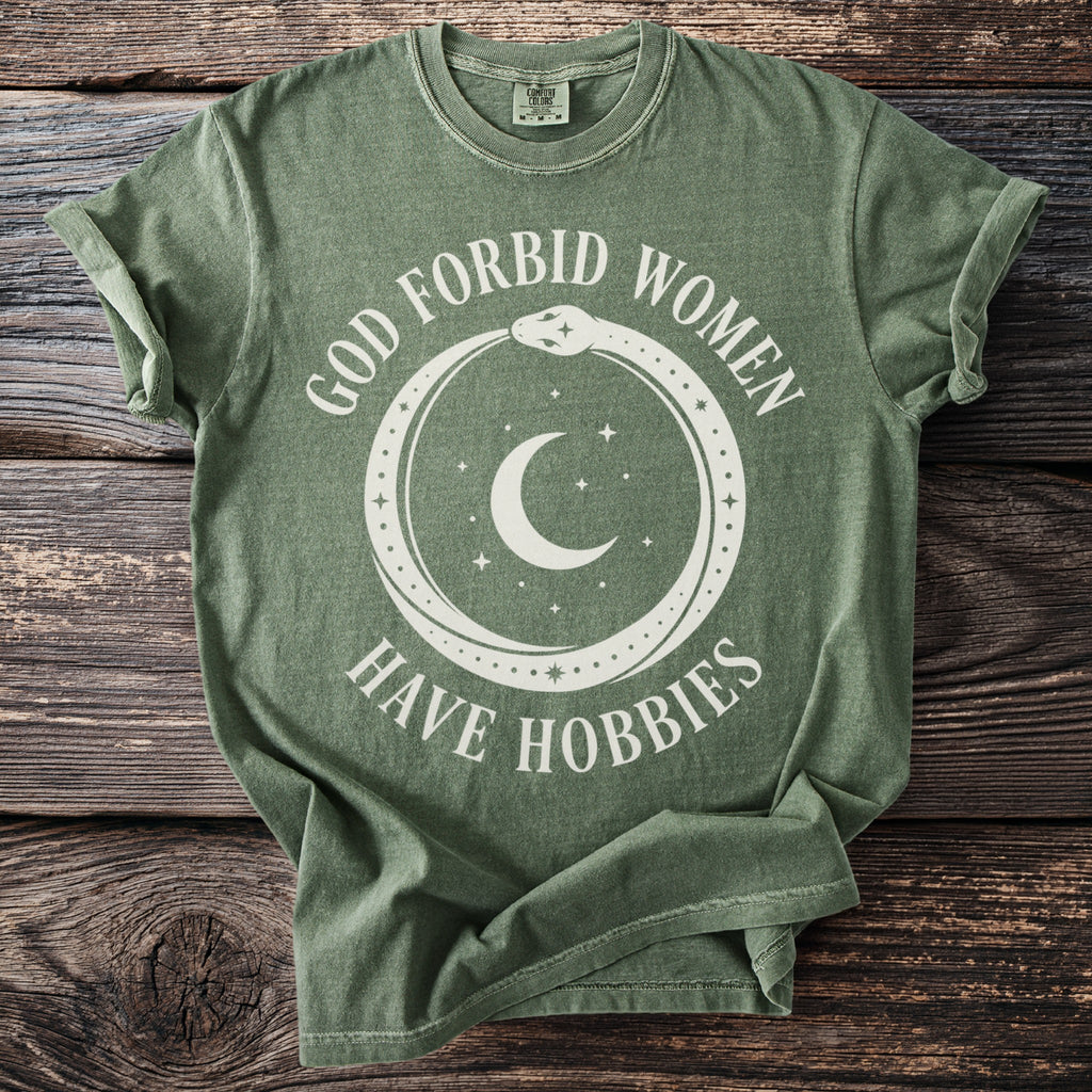 Green t-shirt with white text and graphic of snake, moon, and stars.