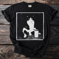 Black t-shirt with a distressed graphic of a tuxedo cat sitting with a can.