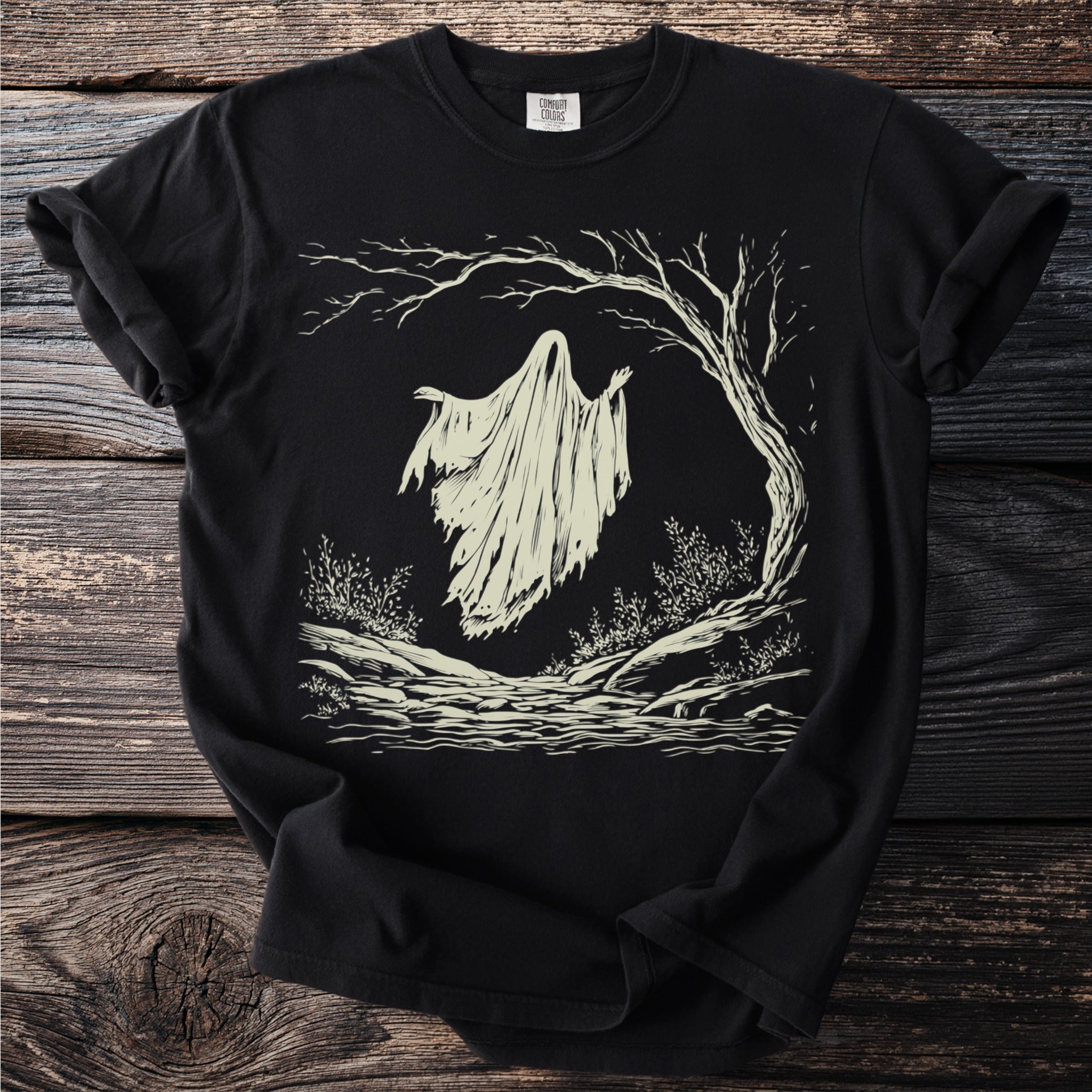 Black t-shirt with a distressed ghost under a creepy tree in light cream.