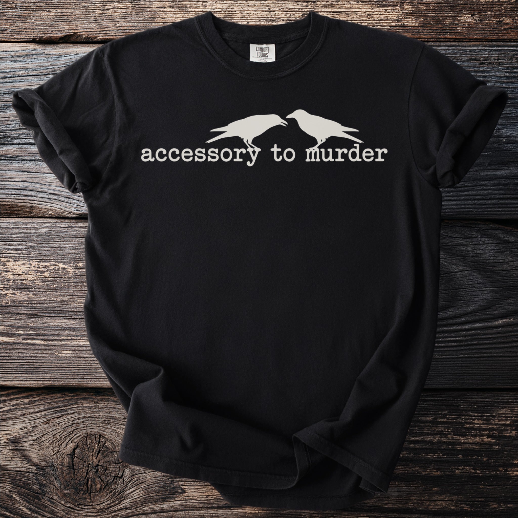 Black t-shirt with two white crows and text, "accessory to murder".