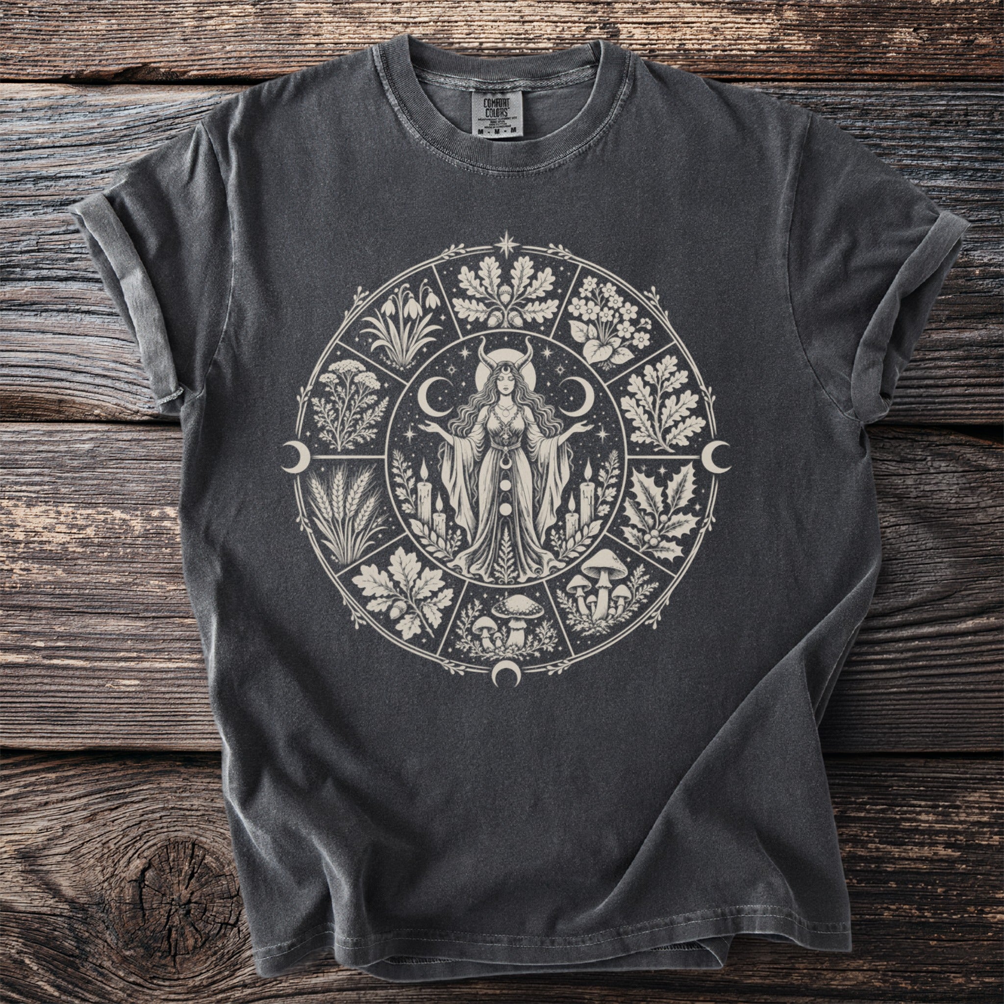 Dark grey t-shirt with a circular design featuring a goddess and seasonal elements.