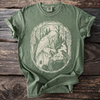 Green t-shirt with a white graphic of a witch brewing a potion with a raven.