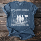 Blue t-shirt with "protect our national parks or we'll haunt your backyard" and ghost graphic.