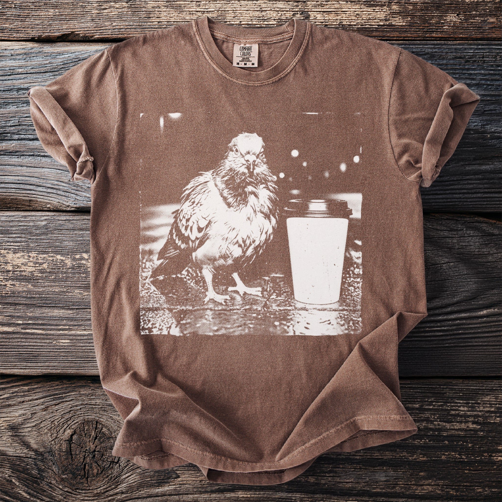Brown t-shirt with a graphic of a pigeon and coffee cup.