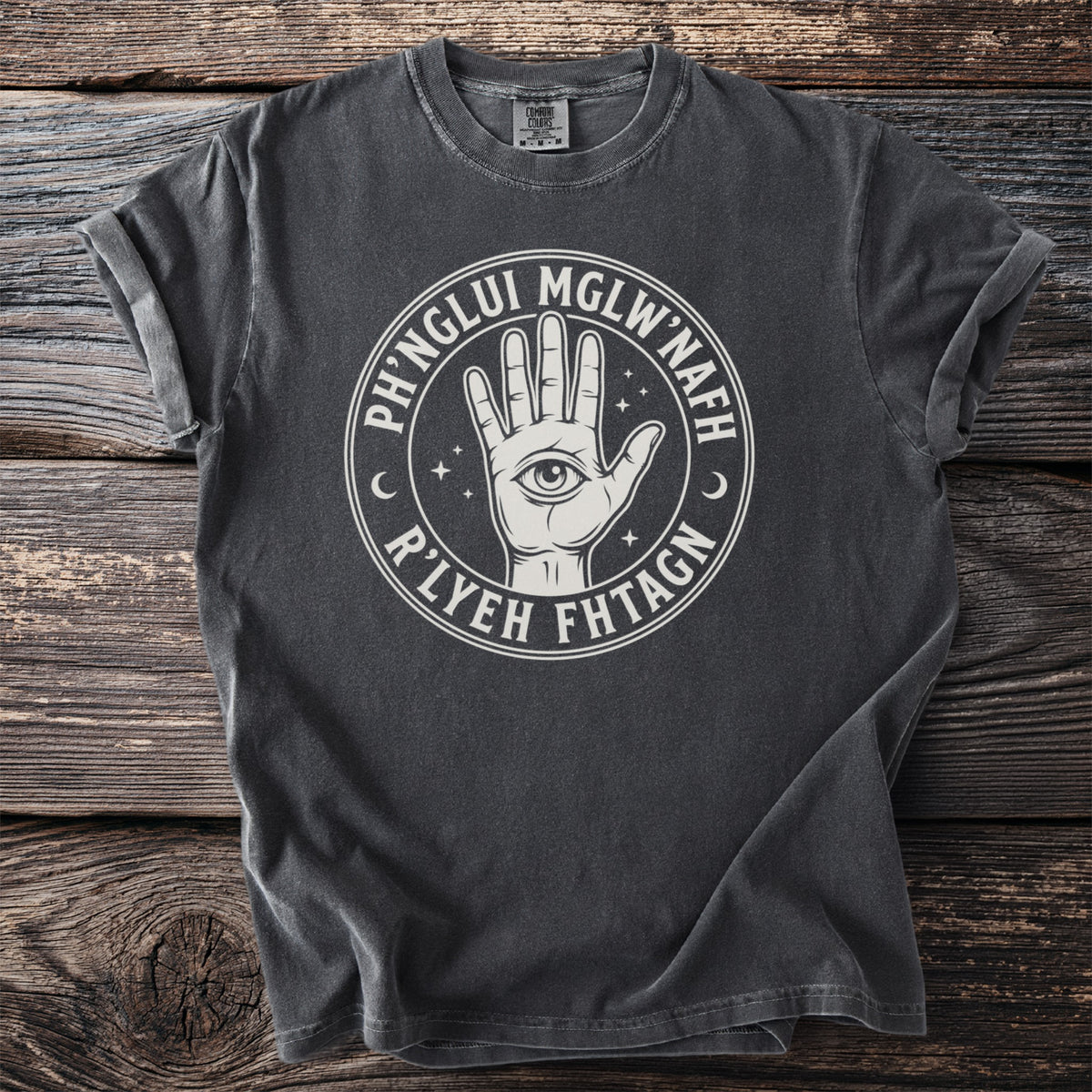 Dark t-shirt with circular graphic featuring an eye in a hand and text.
