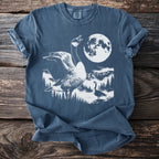 Blue t-shirt with graphic of geese in a forest under a full moon.
