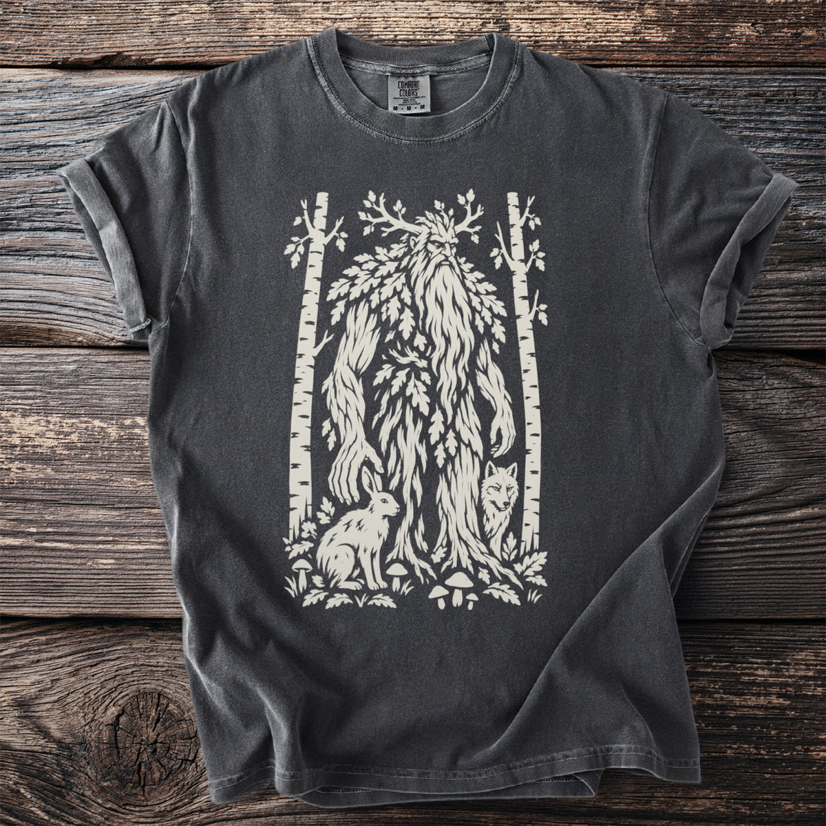 Dark t-shirt with a cream graphic of a leafy forest spirit, rabbit, fox, and birch trees.