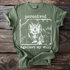 Green t-shirt with white graphic of an owl and text "perceived against my will".