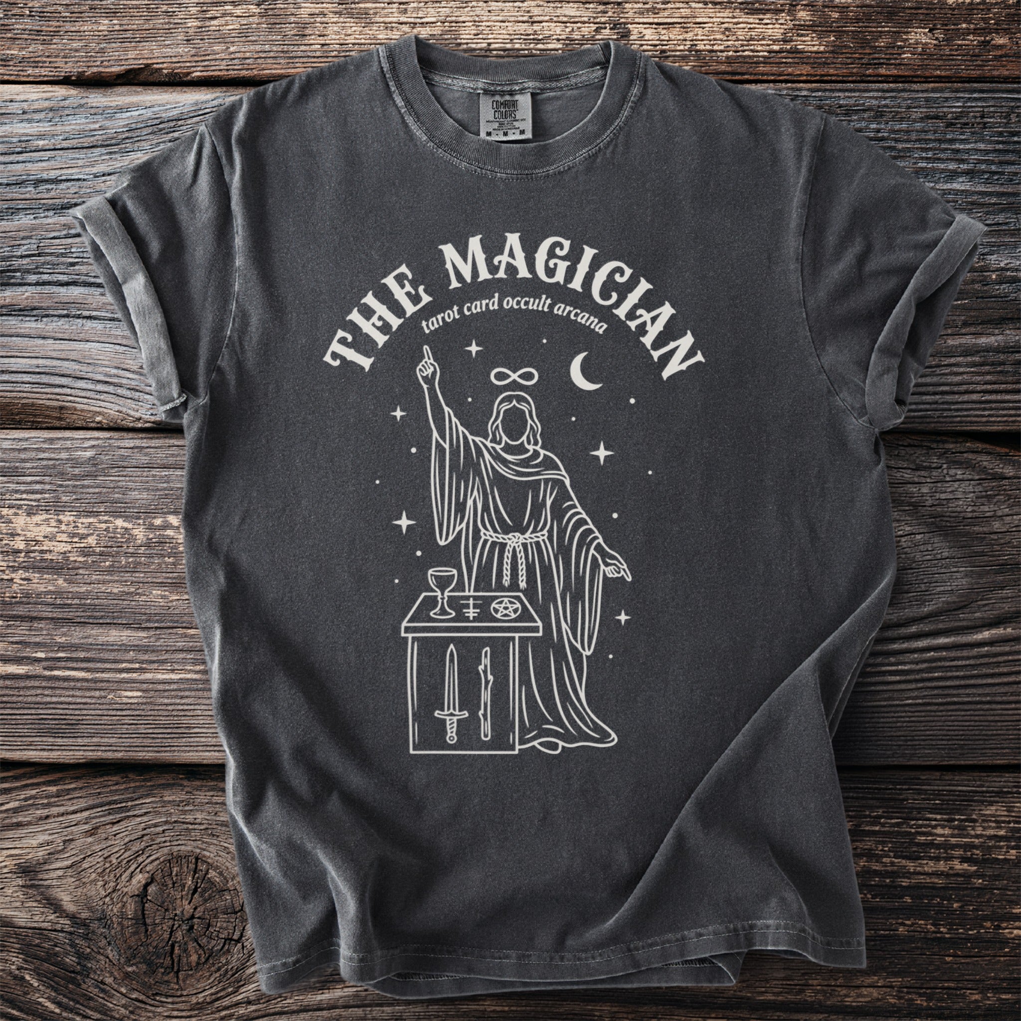 Dark gray t-shirt with "The Magician" tarot design featuring a robed figure and occult symbols.