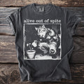 Dark gray t-shirt with "alive out of spite" and wolf watering a plant graphic.