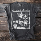 Dark gray t-shirt with "alive out of spite" and wolf watering a plant graphic.