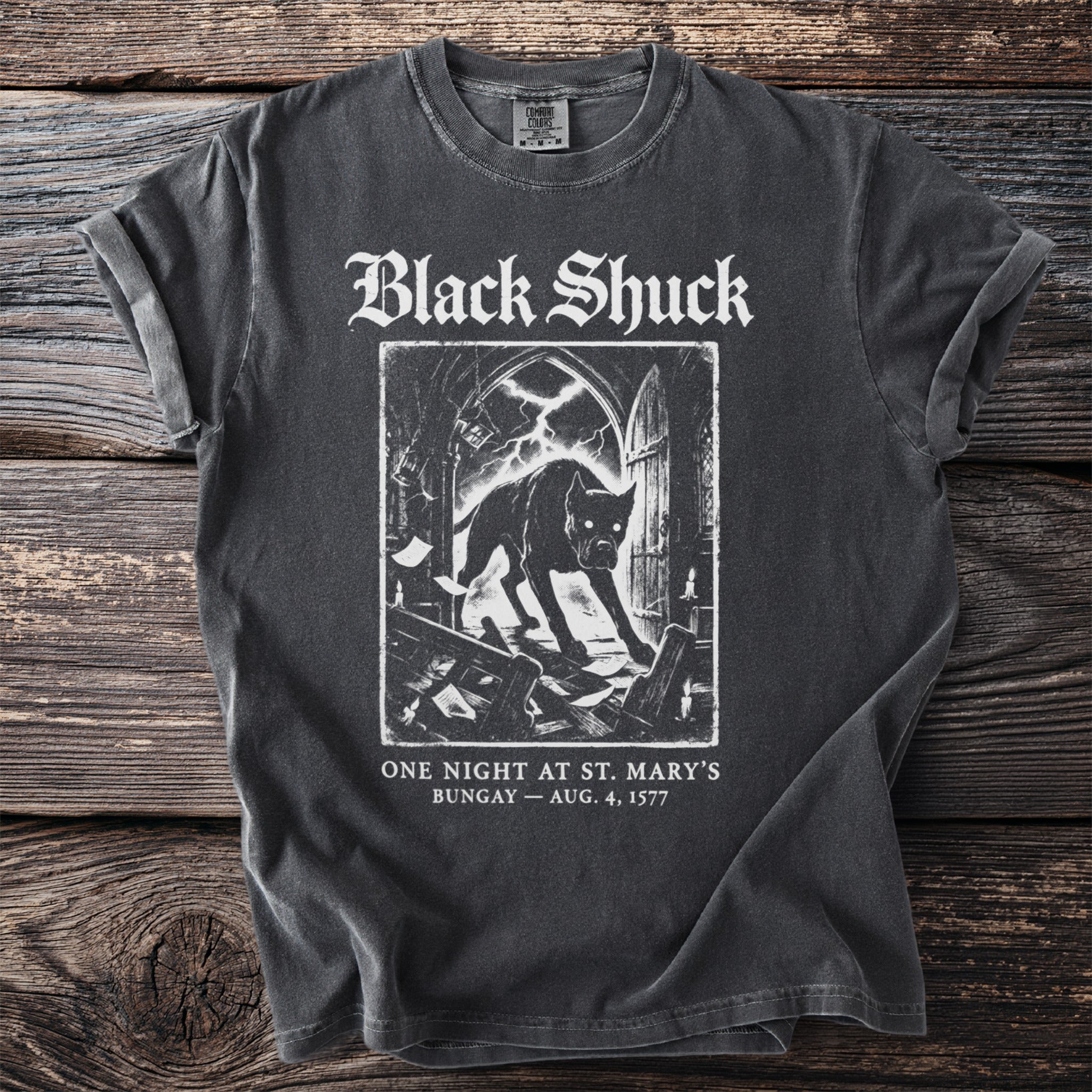 Dark t-shirt with "Black Shuck" and demonic dog graphic, "One Night at St. Mary's Bungay" text.