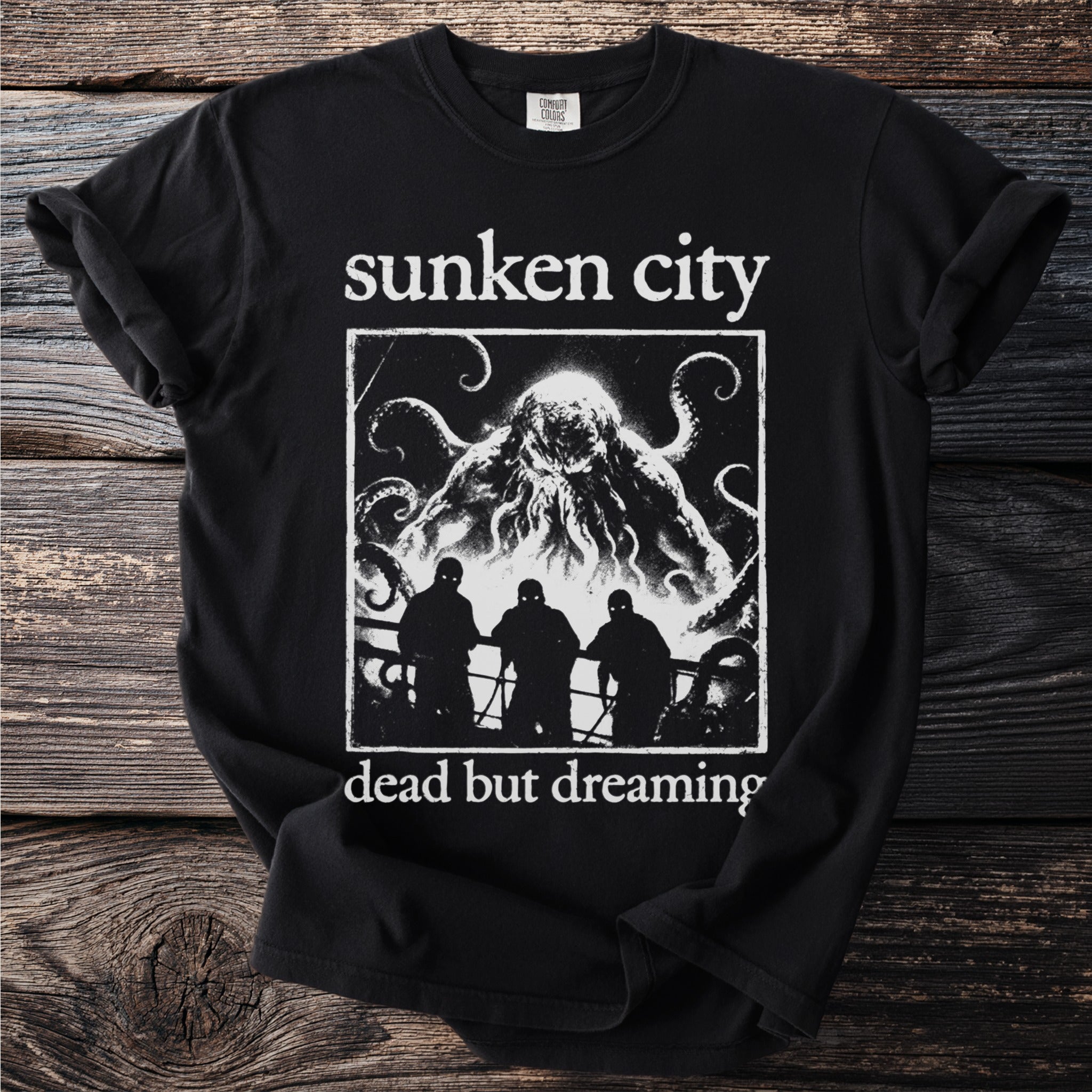 Black t-shirt with "sunken city dead but dreaming" and creature graphic.