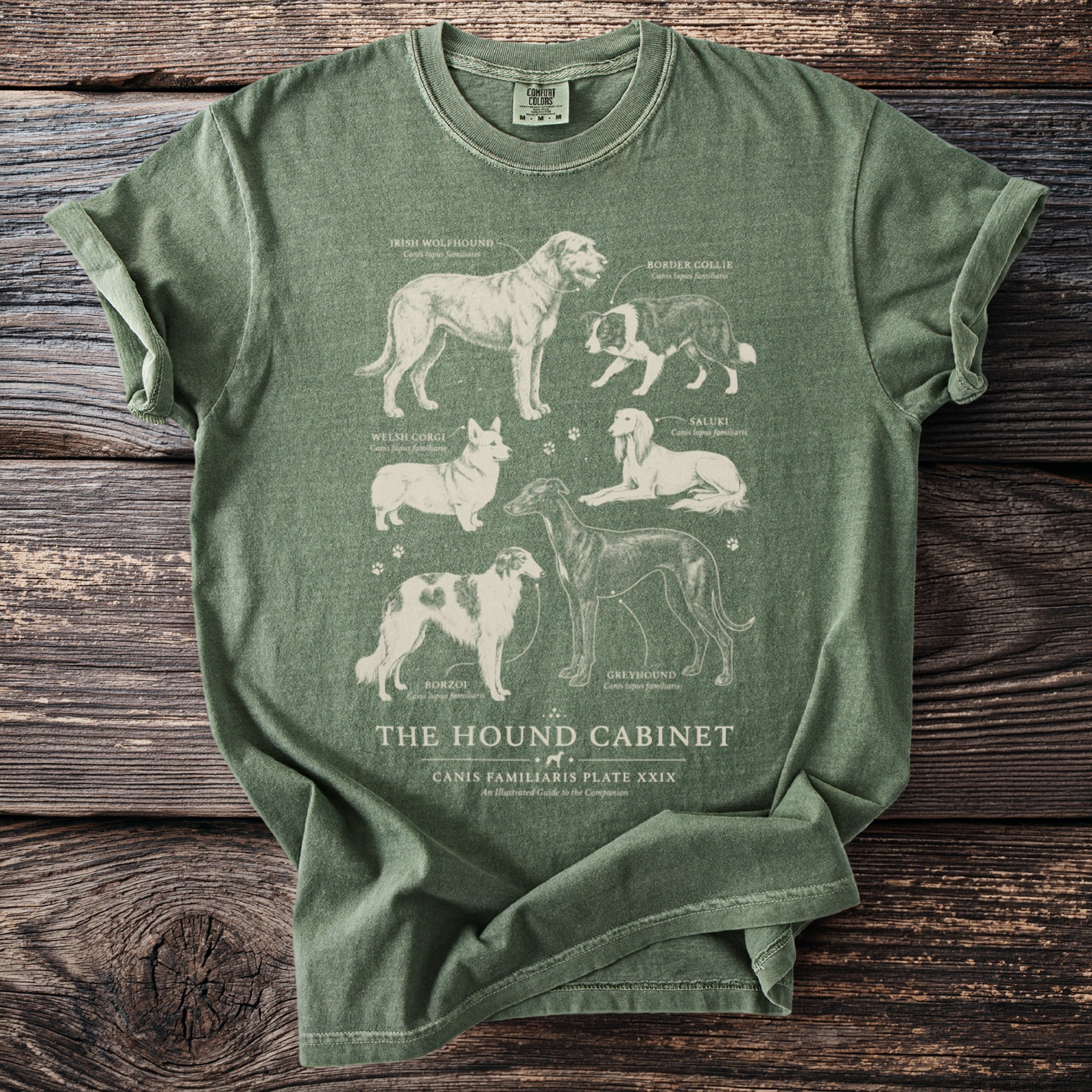 Olive green t-shirt featuring illustrations of six dog breeds with their names and scientific names.