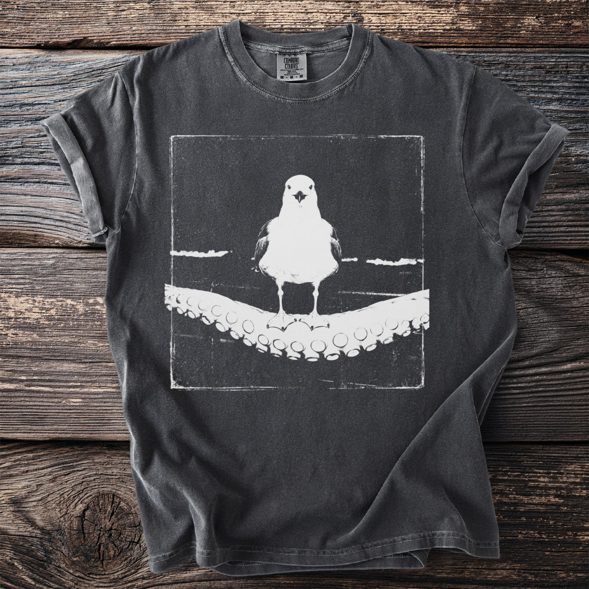 Gray t-shirt with white graphic of a seagull standing on an octopus tentacle.