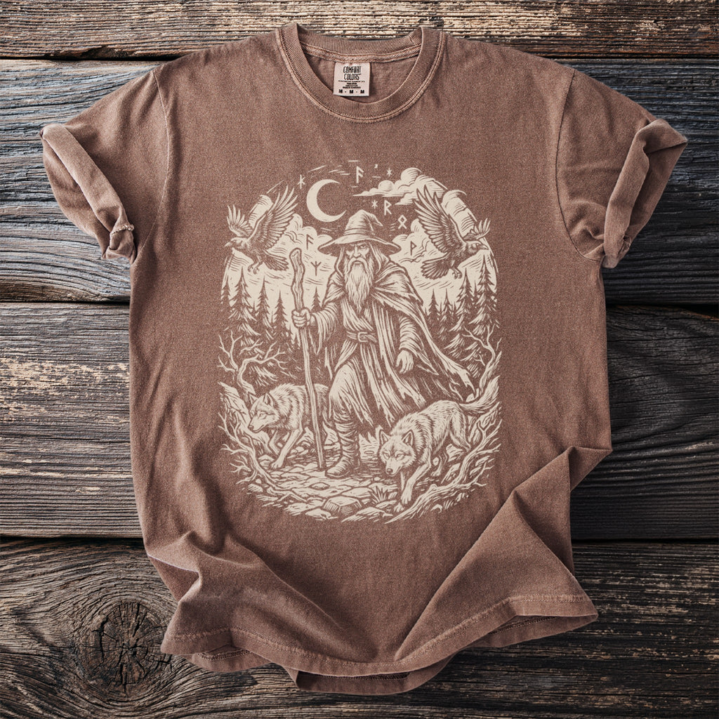Brown t-shirt with a black and white graphic of a wizard, wolves, and birds in a forest.