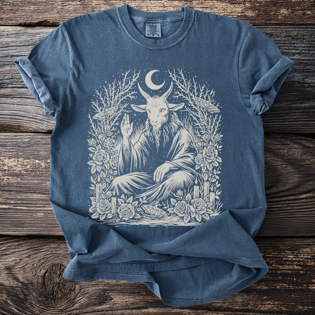 Blue t-shirt with cream print of a goat, moon, moths, roses, and candles.