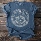 Blue t-shirt with a circular design of fairies dancing under mushrooms and a moon.