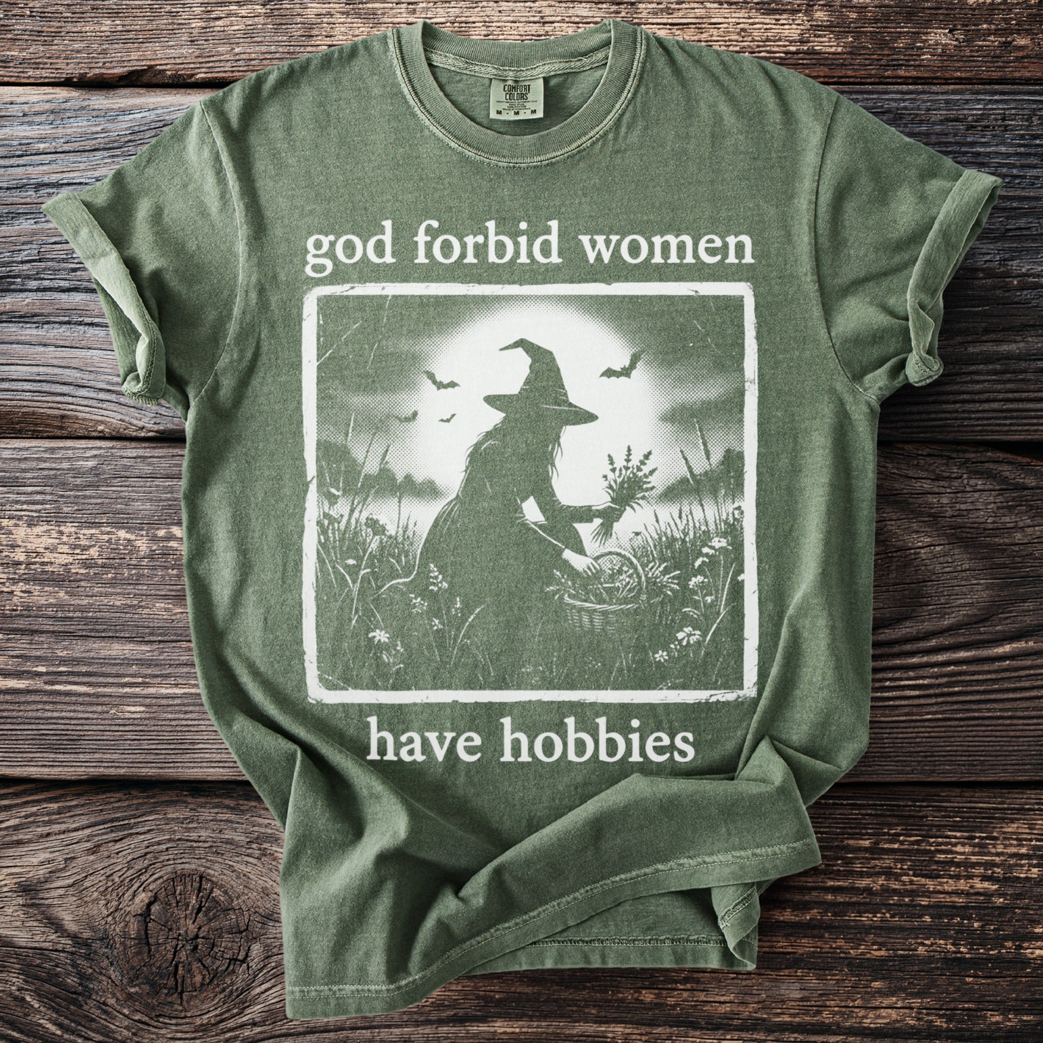 Green t-shirt with graphic and text "god forbid women have hobbies".