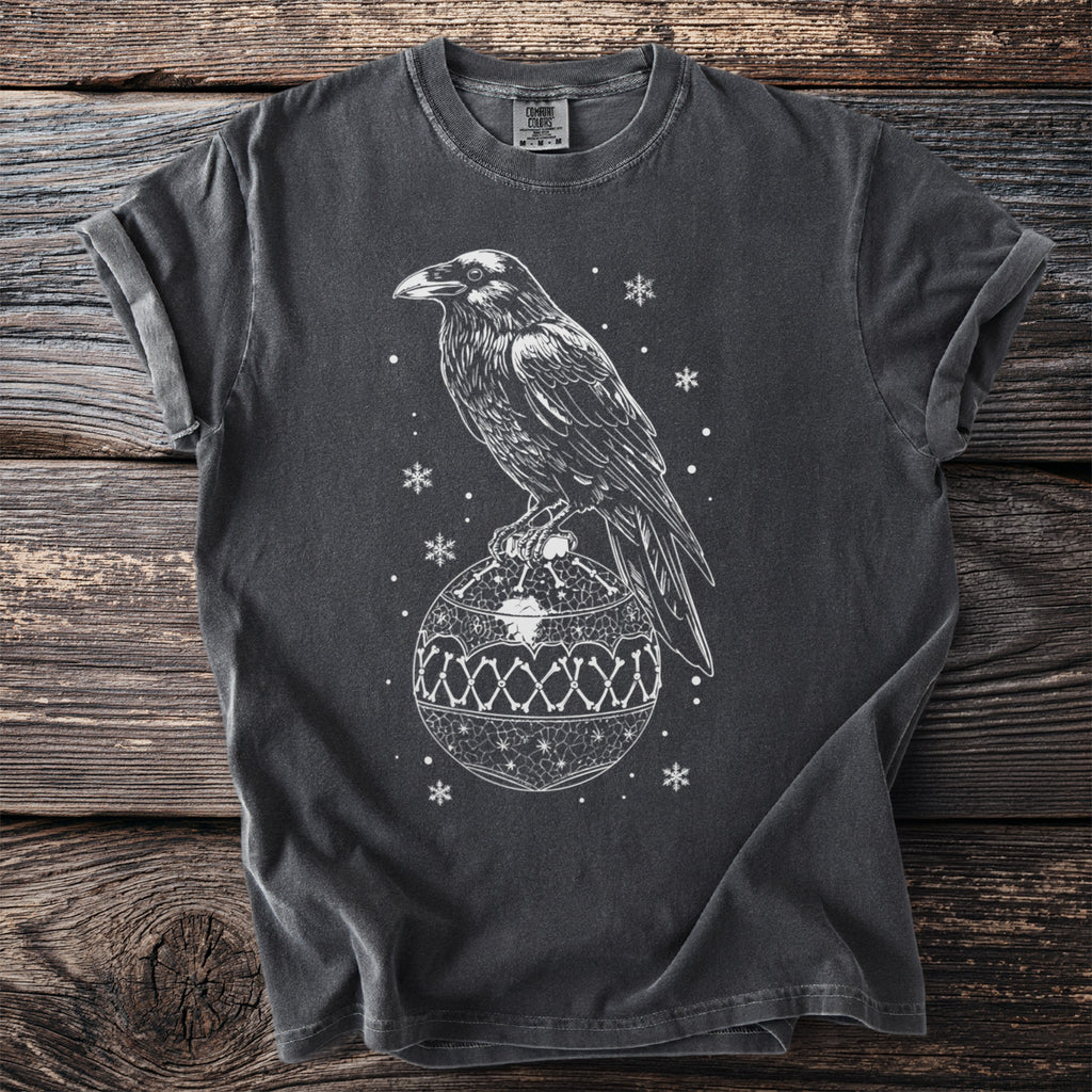 Dark gray t-shirt with white raven perched on a bone-patterned Christmas ornament.