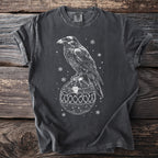 Dark gray t-shirt with white raven perched on a bone-patterned Christmas ornament.