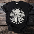 Black t-shirt with a cream-colored illustration of a creature with wings and tentacles.