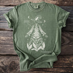 Green t-shirt with a white graphic of a witch's hat and botanical illustrations of foxglove and lily of the valley.