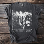 Dark t-shirt with graphic of three women in a cornfield, one holding a jack-o'-lantern, text reads "girls will be girls."