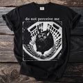 Black t-shirt with "do not perceive me" text and a wide-eyed black cat in a laundry basket.