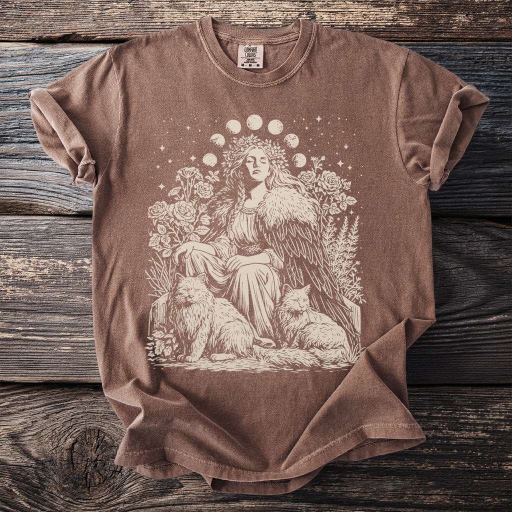 Brown t-shirt with cream graphic of a woman, two cats, and moon phases.