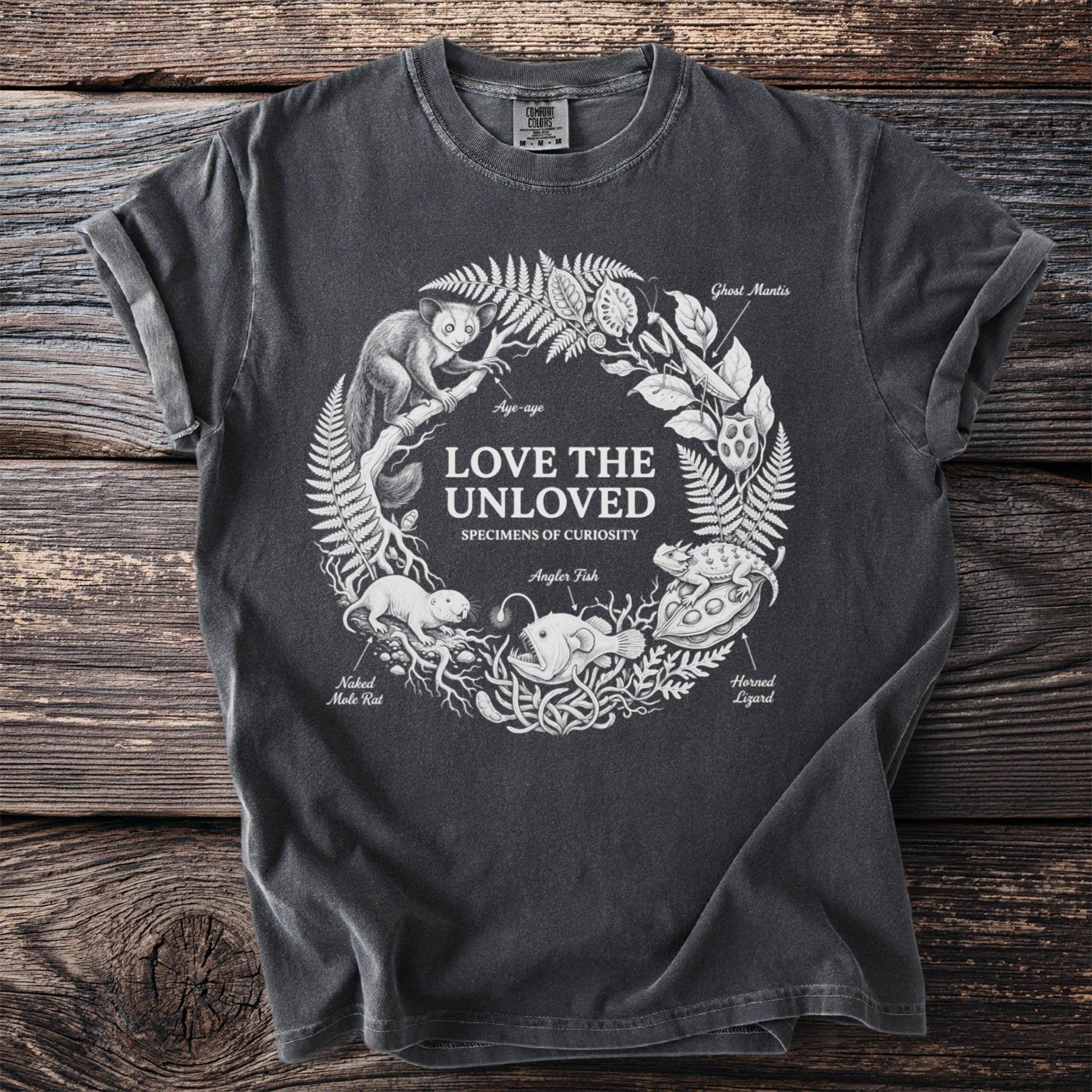 Dark grey t-shirt with "Love the Unloved Specimens of Curiosity" and illustrations of obscure animals.