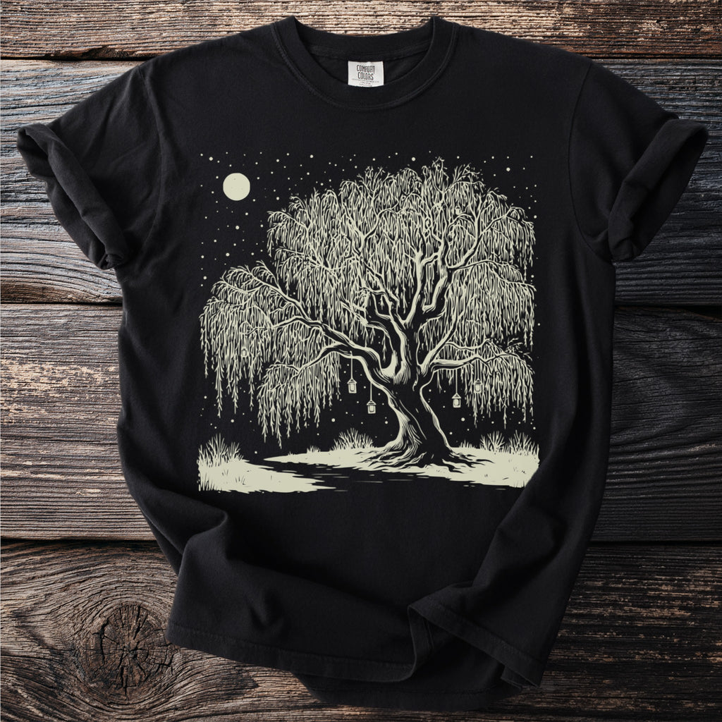Black t-shirt with a linocut style print of a weeping willow tree under a moonlit starry sky.