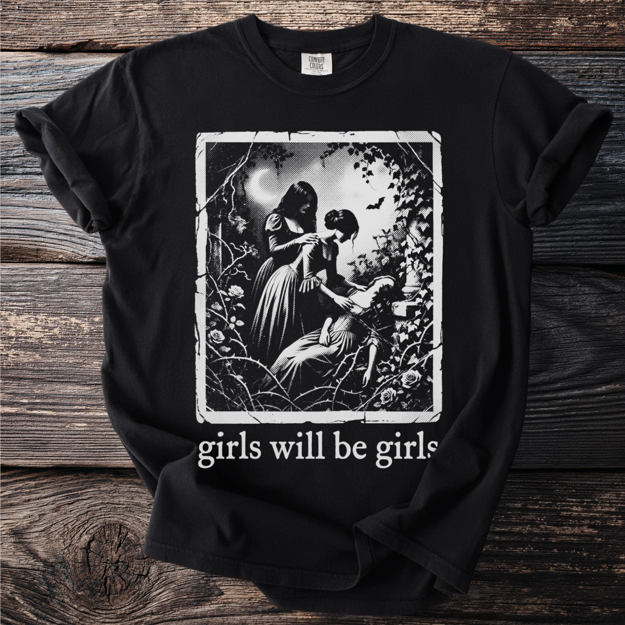Black t-shirt with "girls will be girls" and a gothic illustration of two women with thorns and roses.