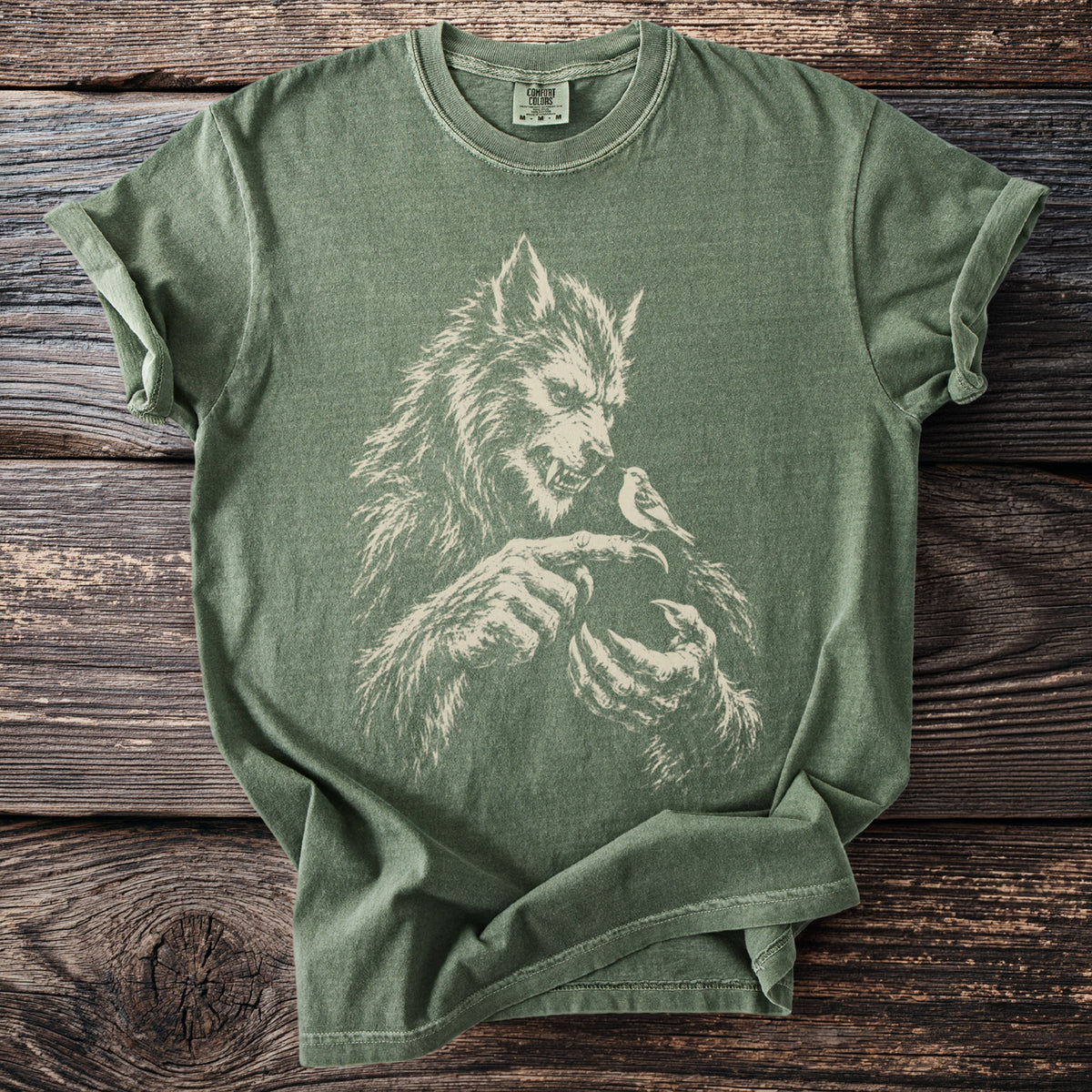 Green t-shirt with distressed werewolf and bird graphic and Comfort Colors tag.
