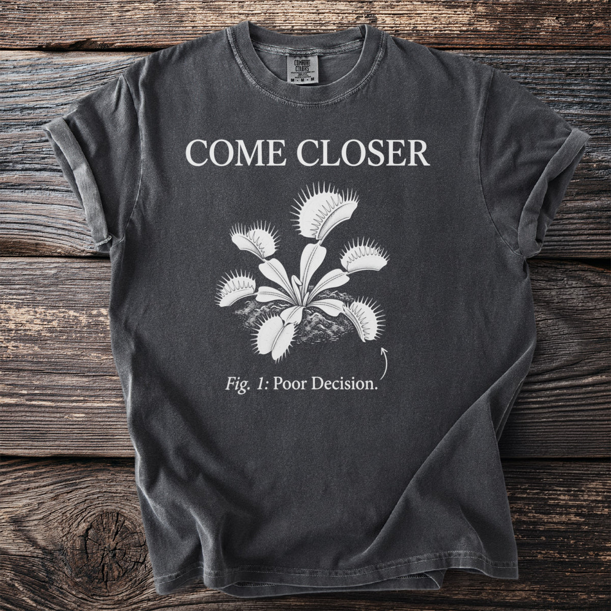 Dark t-shirt with "COME CLOSER" and a Venus flytrap illustration, labeled "Fig. 1: Poor Decision."