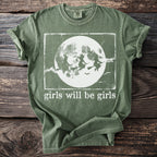 Green t-shirt with witches flying in front of a moon and "girls will be girls" text.