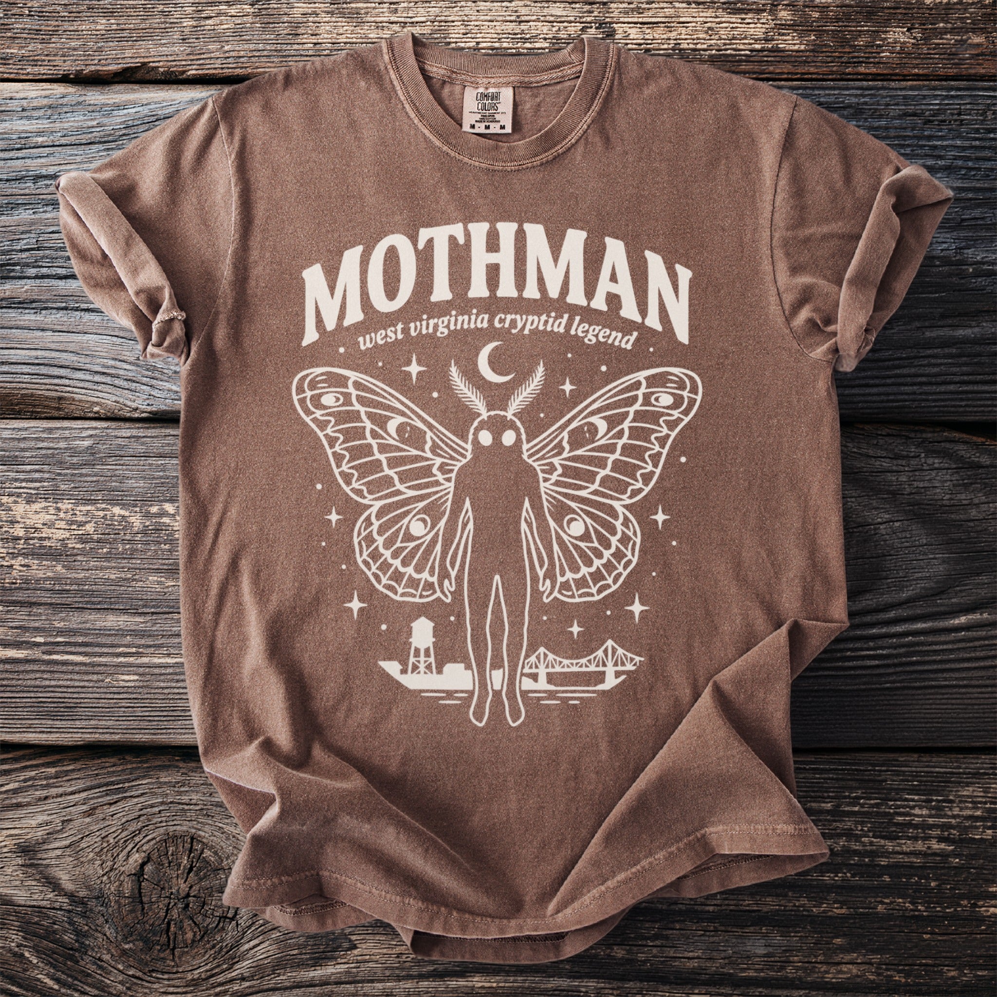 Brown t-shirt with Mothman, wings, West Virginia cryptid legend text, and bridges.