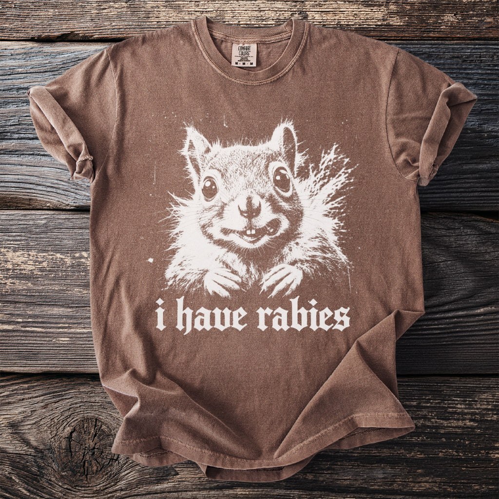 Brown t-shirt with white graphic of a squirrel and text "i have rabies".