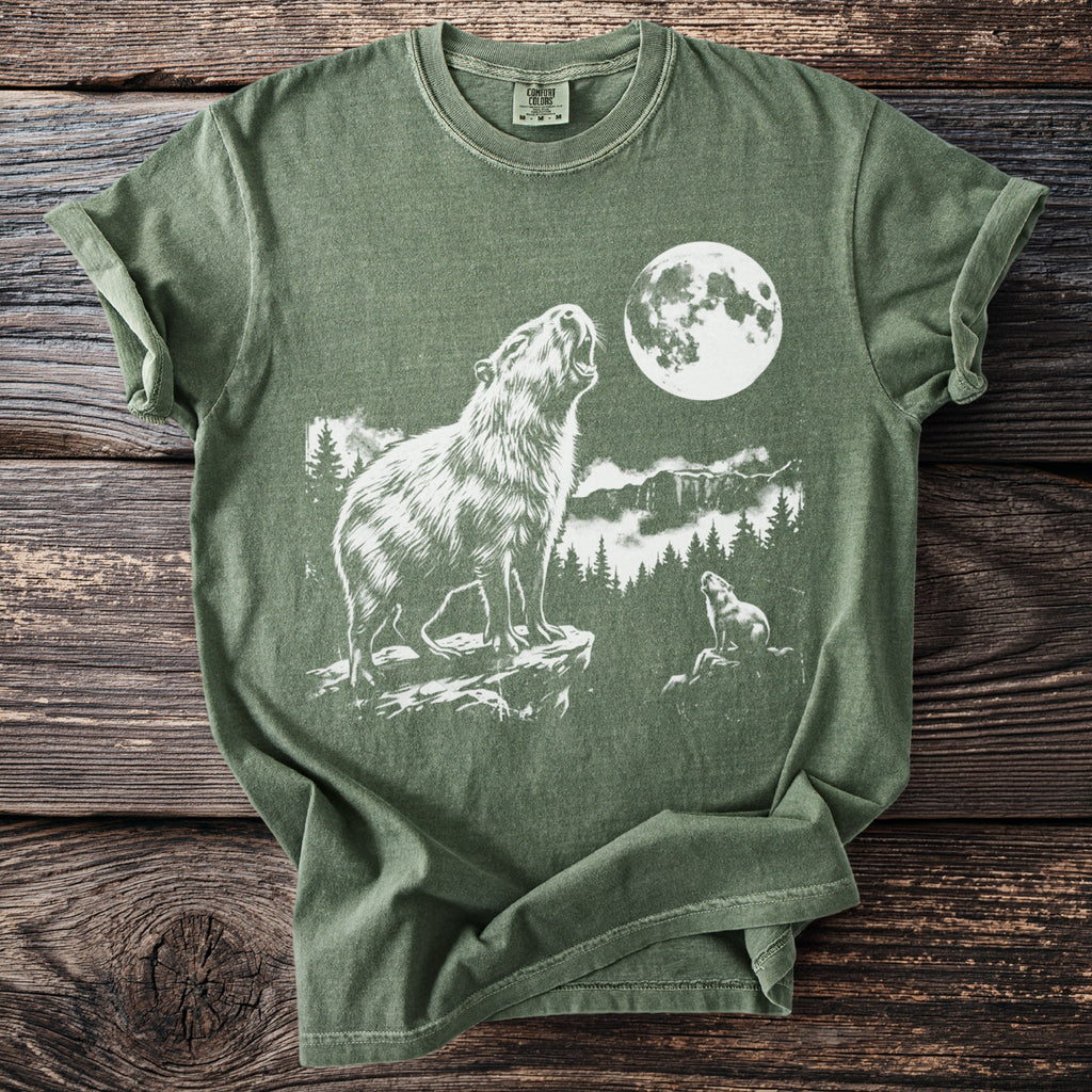 Olive green t-shirt with white graphic of a capybara howling at a full moon, with a smaller capybara below.