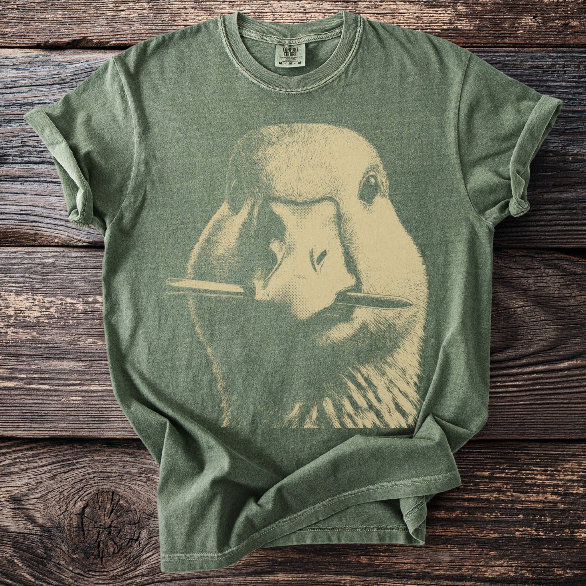 Green t-shirt with a vintage style duck graphic holding a pencil in its beak.