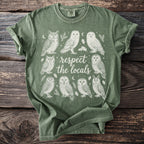 Green t-shirt with a circular owl graphic and "respect the locals" text.