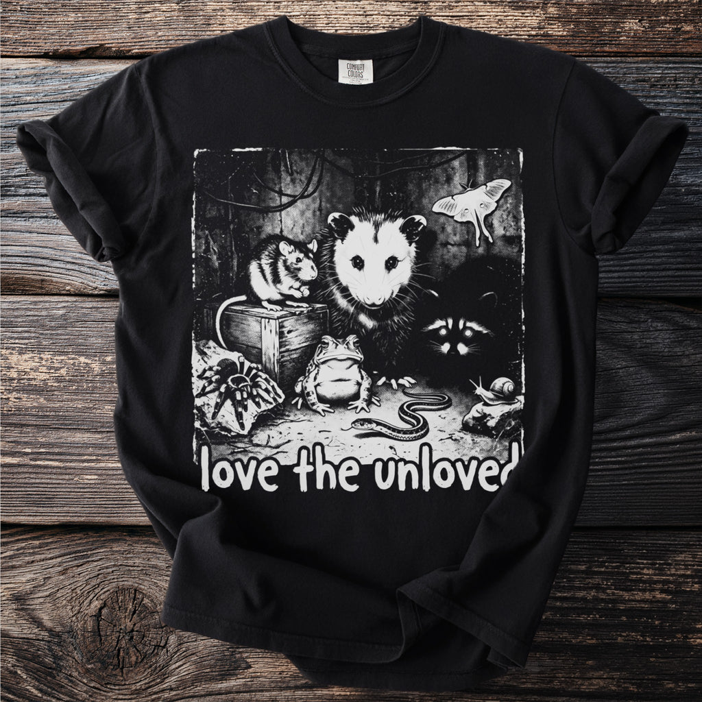 Black t-shirt with a graphic of an opossum, mouse, raccoon, frog, snake, spider, snail, and moth with text "love the unloved".