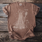 Brown t-shirt with line art of a witch, fox, monkshood, and black hellebore.