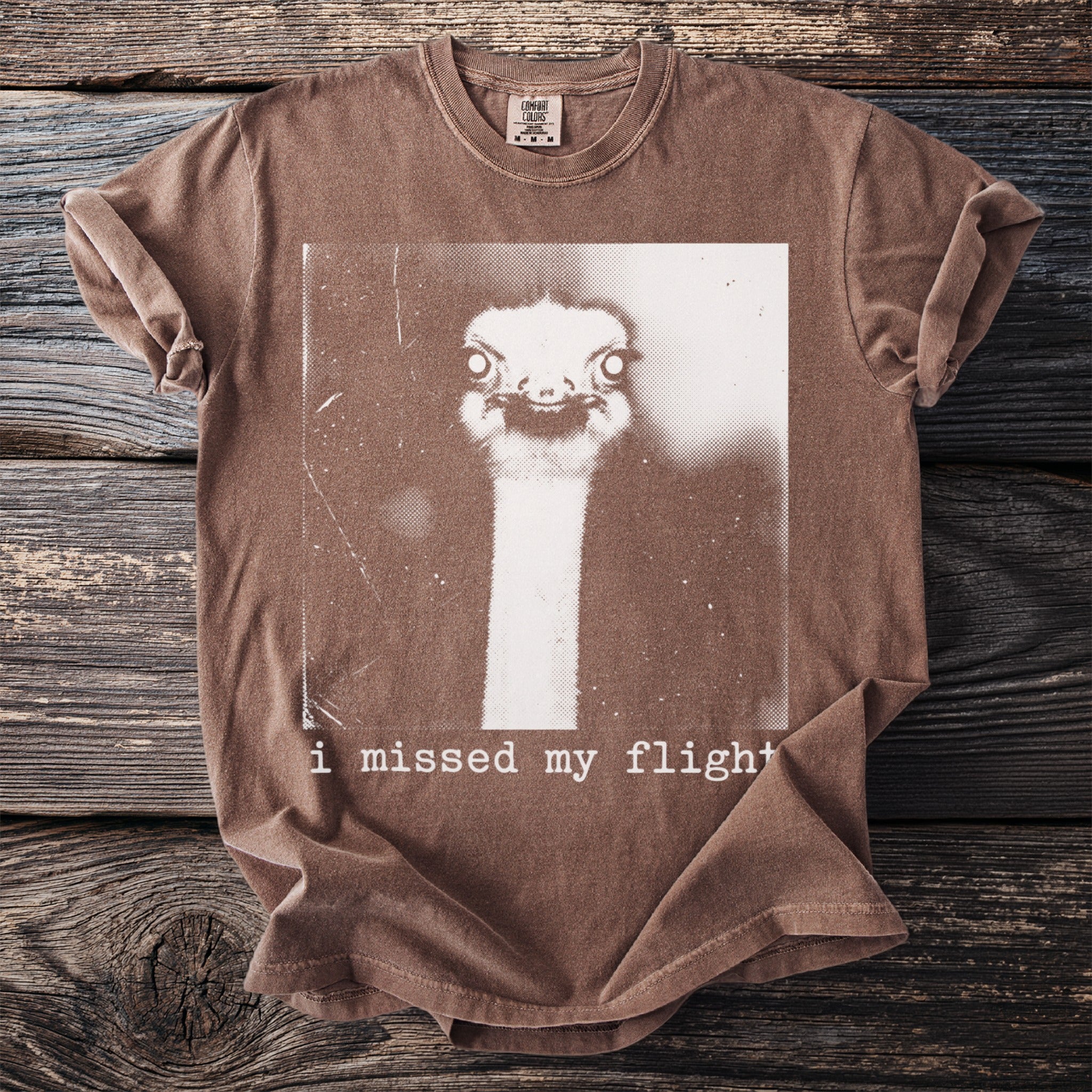 Brown t-shirt with ostrich graphic and text "i missed my flight".