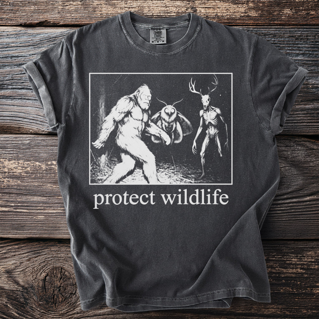 T-shirt with Bigfoot, mothman, and deer skull graphic and "protect wildlife" text.