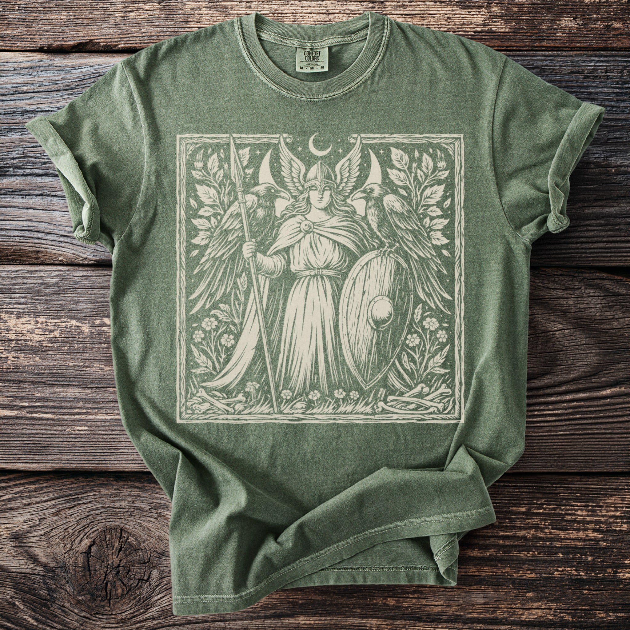 Green t-shirt with a winged warrior and ravens graphic.