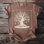 Brown t-shirt with a large, intricate cream-colored tree illustration and mystical decorations.
